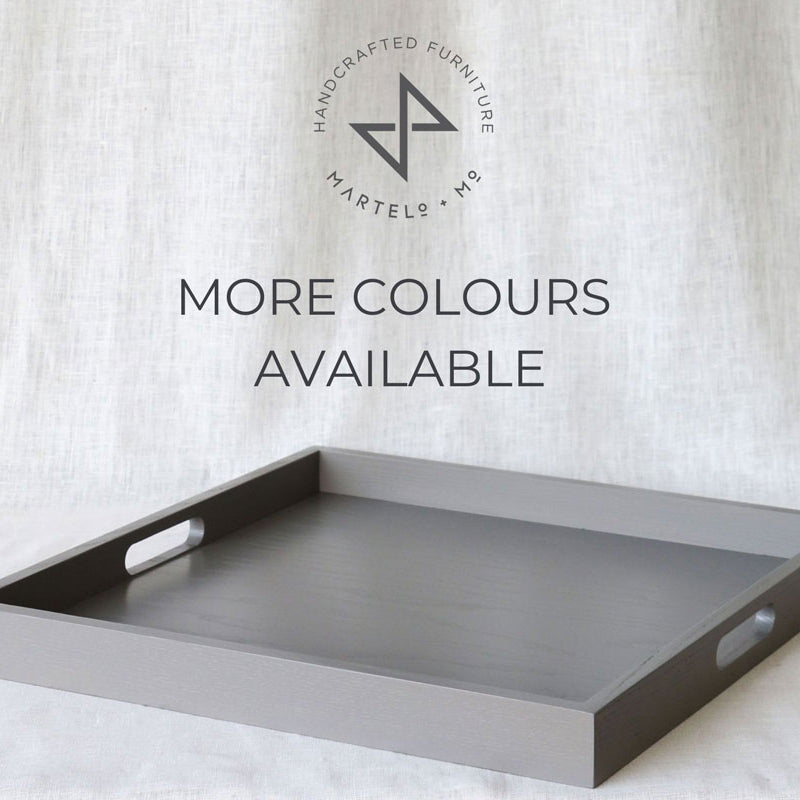 Grey ottoman tray with cut-out handles, displayed on a fabric backdrop with the Martelo & Mo logo and “More Colours Available” text.