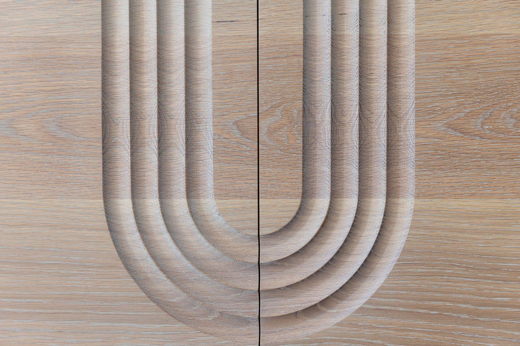 close up of the oak cabinet door fronts with the cnc carved arch detail