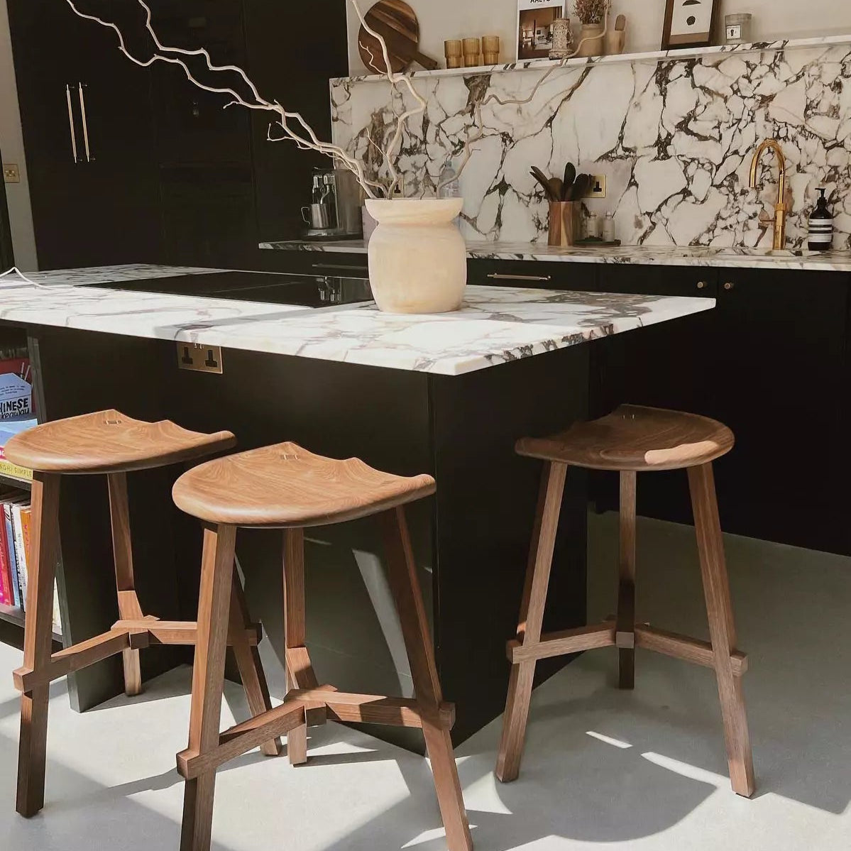 Modern kitchen with marble island and wooden stools