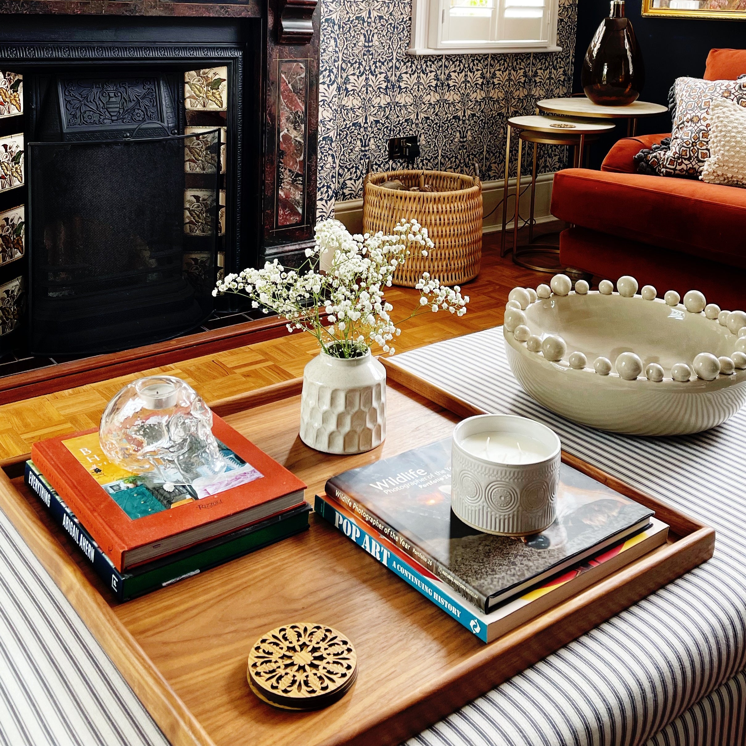 A handcrafted tray used as a coffee table tray, beautifully arranged with books, candles, and ceramics in a living room.