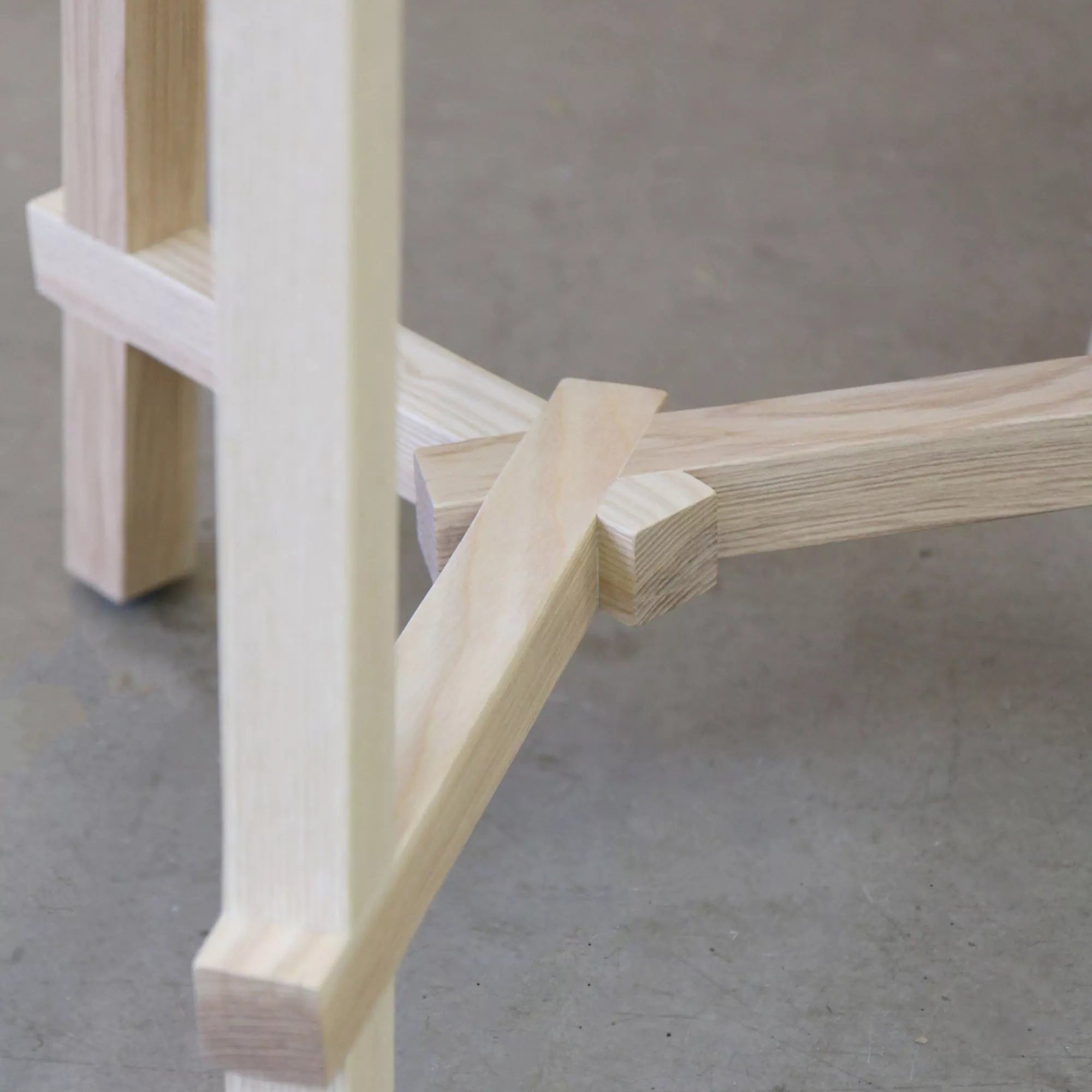 Close-up of a wooden chair leg on a concrete floor