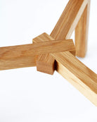 Close-up of a wooden stool frame on a white background