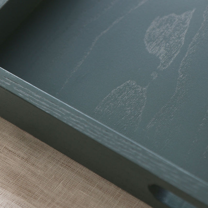 Close-up of the tray’s interior showing visible wood grain beneath the smooth blue-grey painted finish.