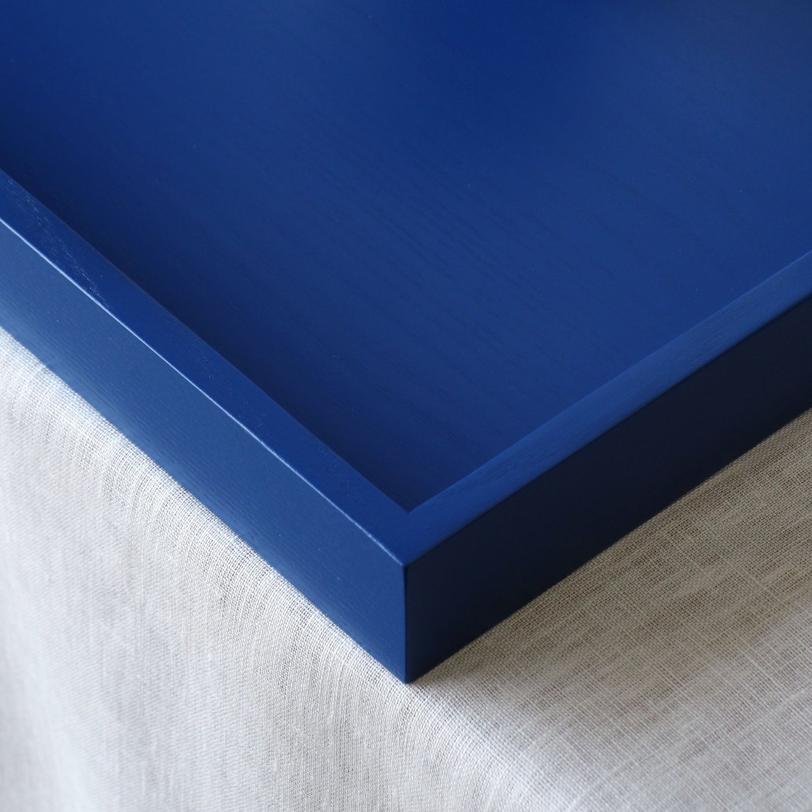 Close-up of a blue tray frame corner on a textured surface