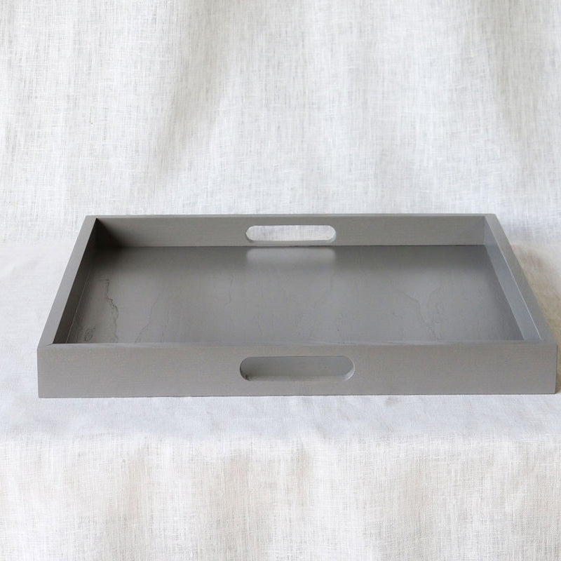 Straight-on view of an empty grey ottoman tray showing both side handles, against a neutral background.