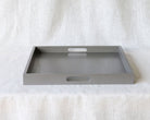Straight-on view of an empty grey ottoman tray showing both side handles, against a neutral background.