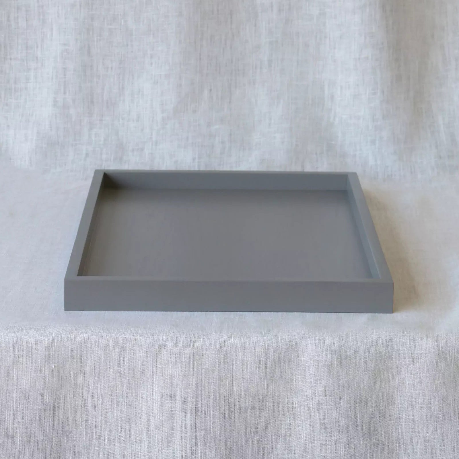 Gray square tray on a textured white surface