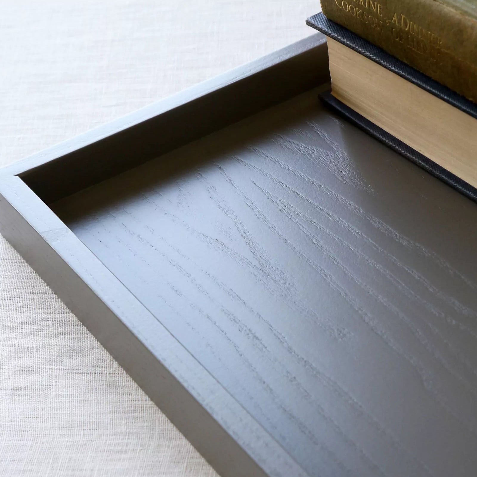 Wooden tray with books on a light background