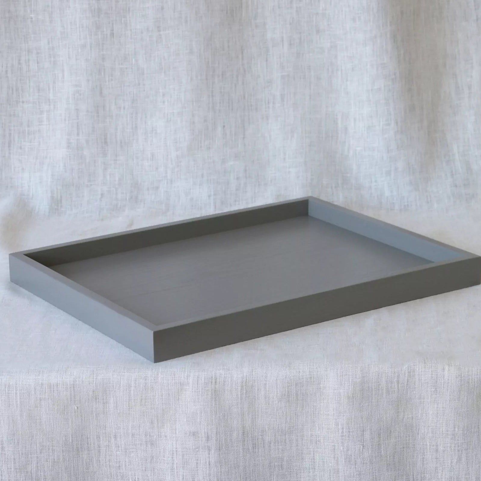Gray rectangular tray on a textured white surface