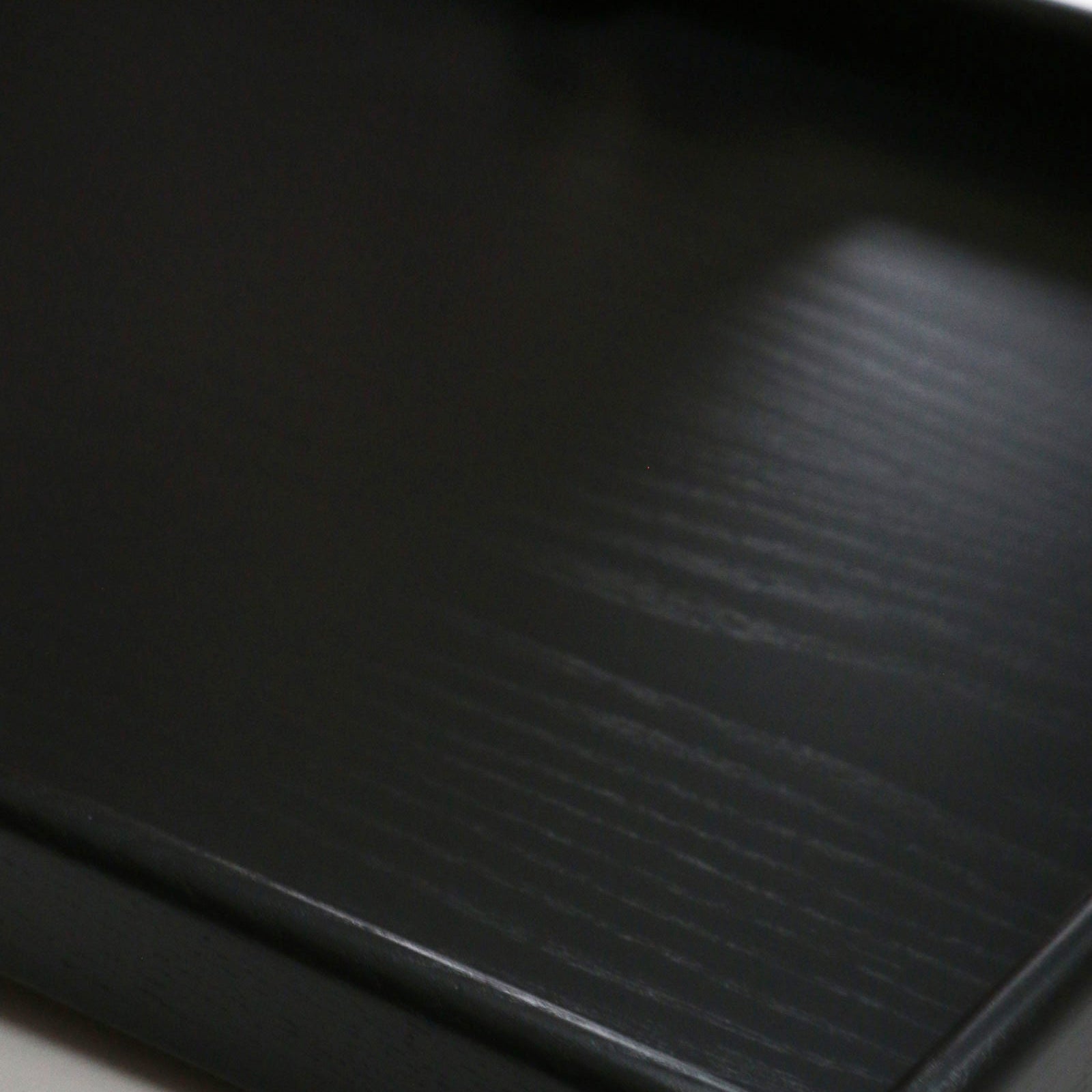 A coffee table tray in black wood, styled with home décor elements, creating a modern and elegant aesthetic.