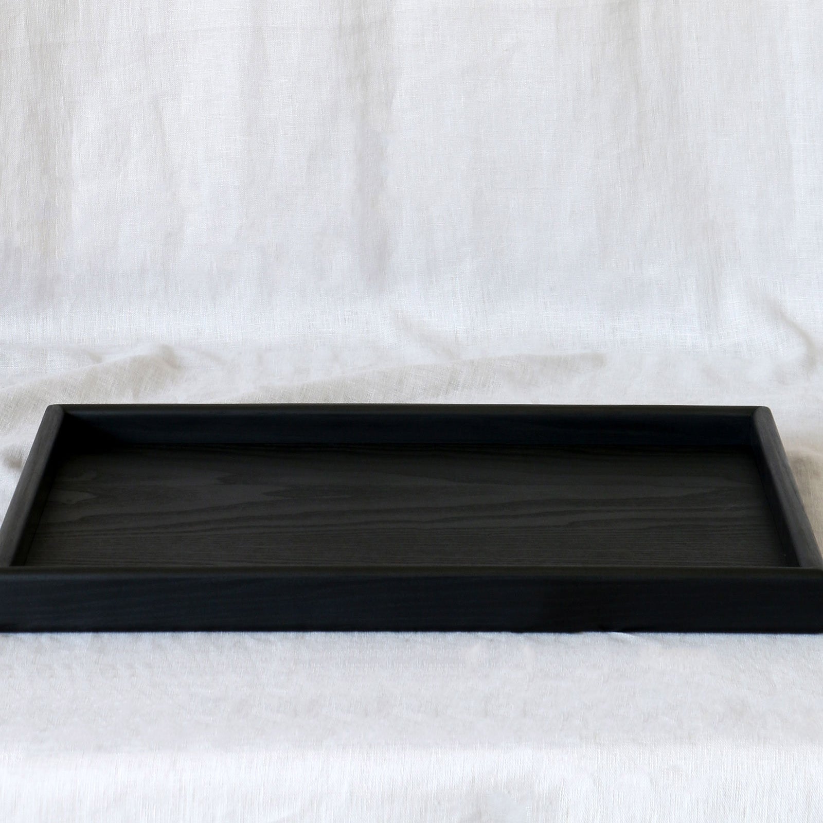 A close-up of a handcrafted tray, highlighting its sleek black finish and fine craftsmanship.