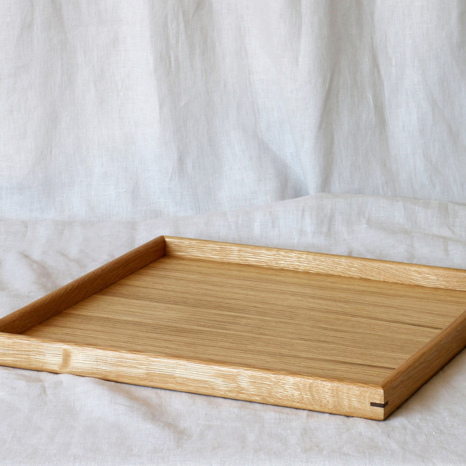 A close-up of a handcrafted tray, highlighting its elegant oak wood grain and precise craftsmanship, ideal as a coffee table tray.