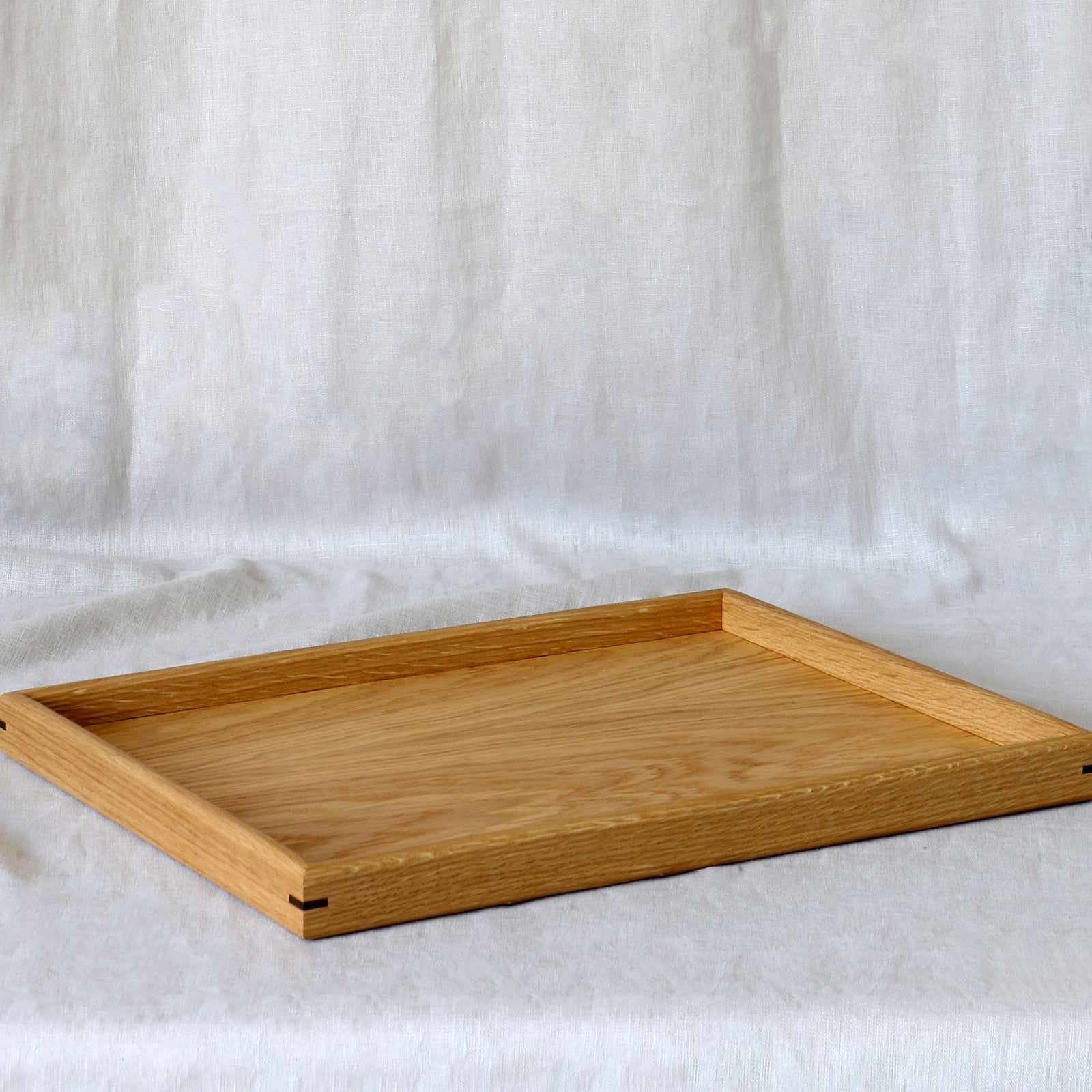 A large coffee table tray, featuring fine joinery details and a natural oak finish, designed for functional elegance.