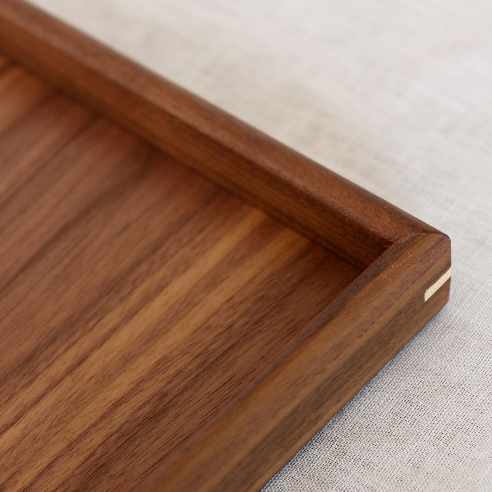 A handcrafted tray placed on an ottoman in an elegant living space, adding a functional yet stylish touch.