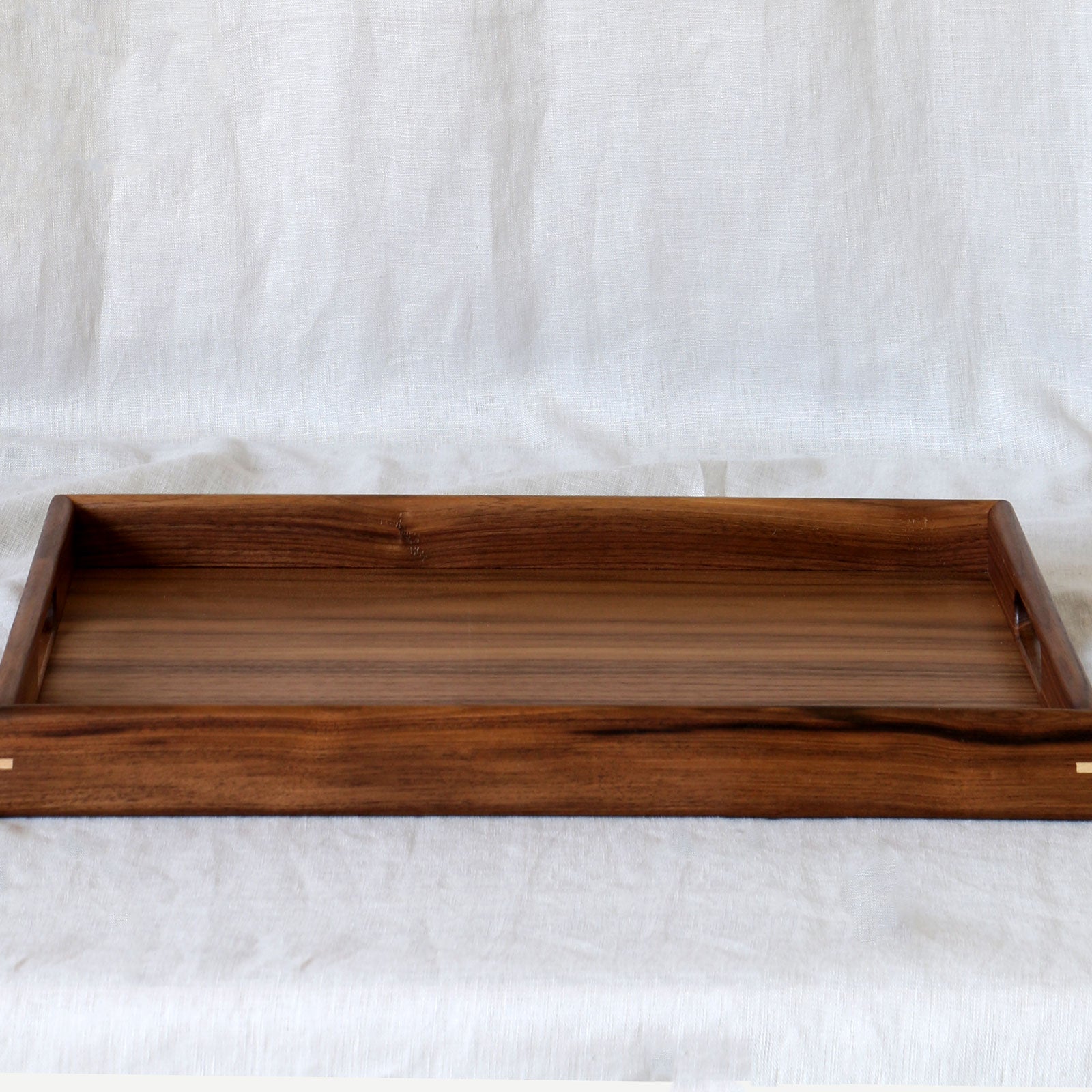A large wooden footstool tray in walnut, featuring dovetail joinery and a finely polished surface.