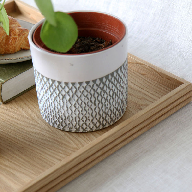 Close-up view of the oak tray corner showcasing the textured potted plant and the tray's smooth wood grain and fine craftsmanship.