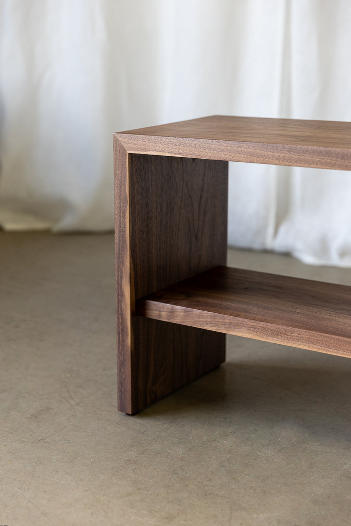 Close-up view of the front of a Walnut Bench, highlighting meticulously crafted mitre joinery for durability and a functional shelf, combining timeless elegance with practicality for long-lasting appeal