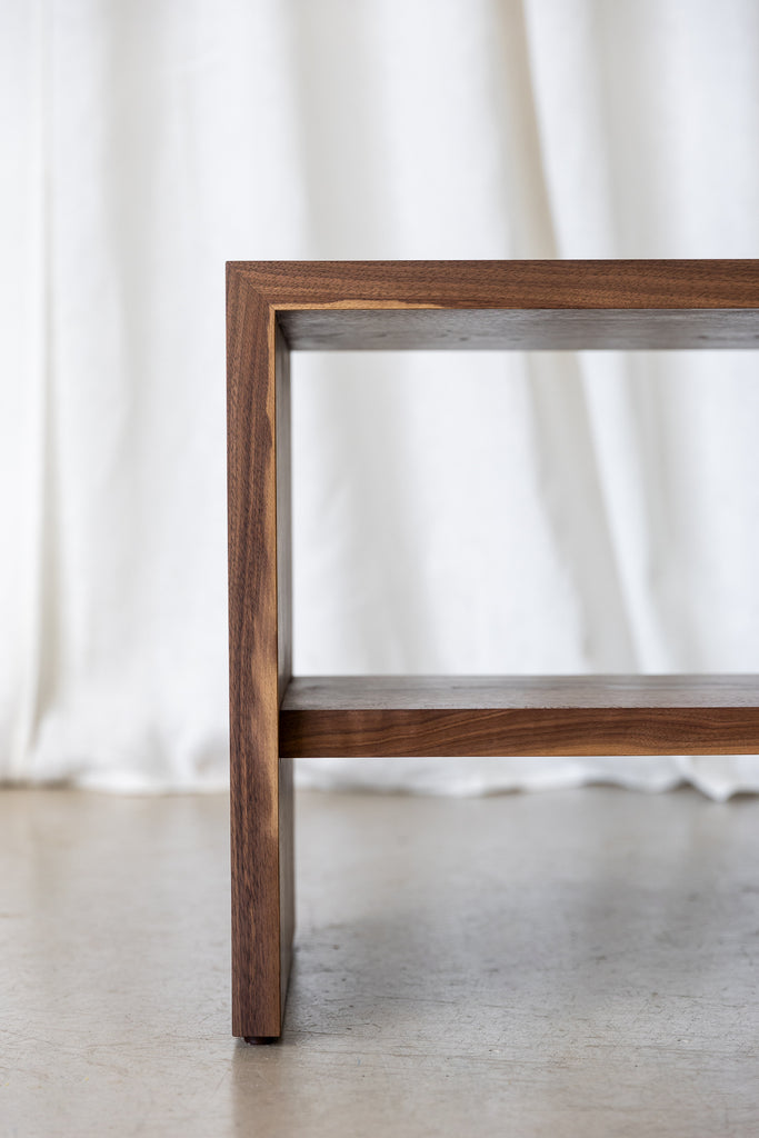 Close-up of Walnut Bench front, featuring mitre joinery for durability and a practical shelf.