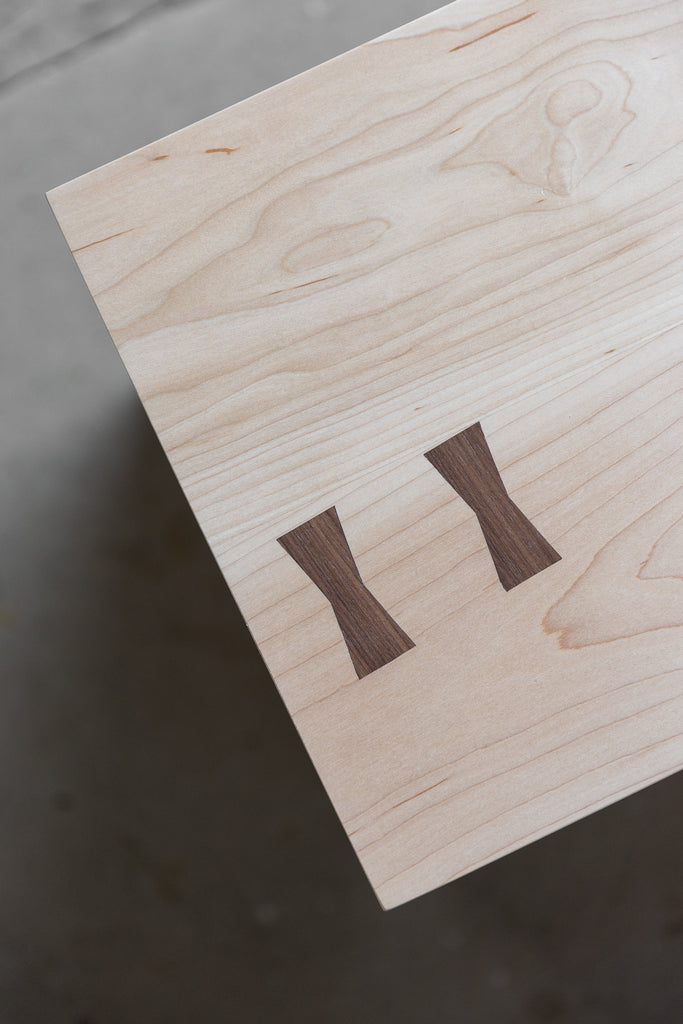 close up image of contrasting Walnut bow-tie details on a Maple Bench top 