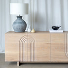 Light Oak Sideboard with arched detailed carved into the door fronts, styled with lamp and vases