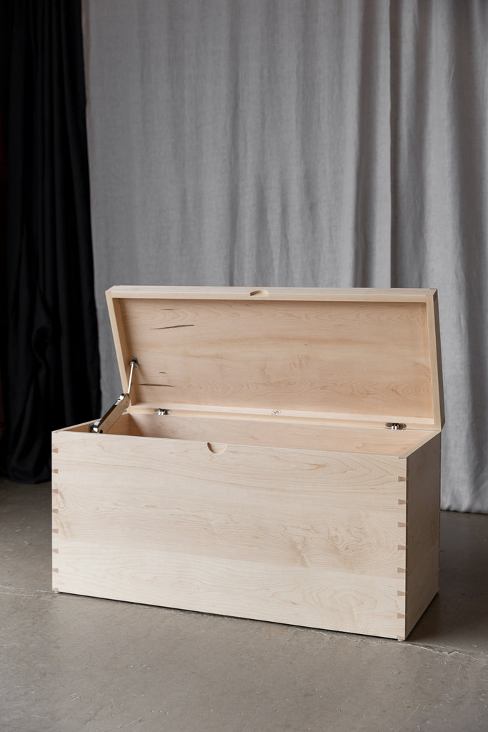 Maple Blanket Box featuring corner dovetail joinery, with an open lid showcasing robust soft-close hardware for added convenience and durability.