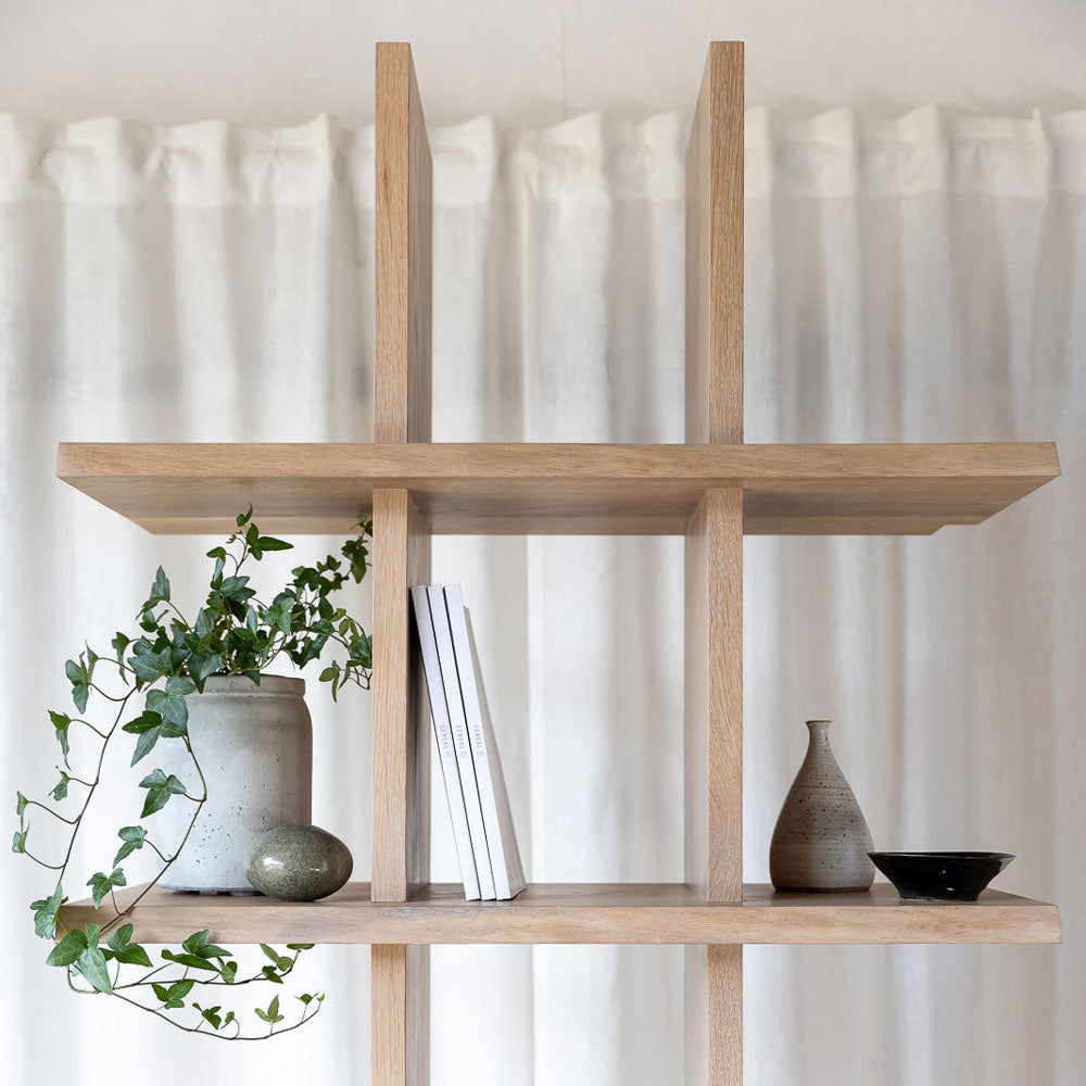 close-up view of the bookcase, styled with a ivy plant, books and vases