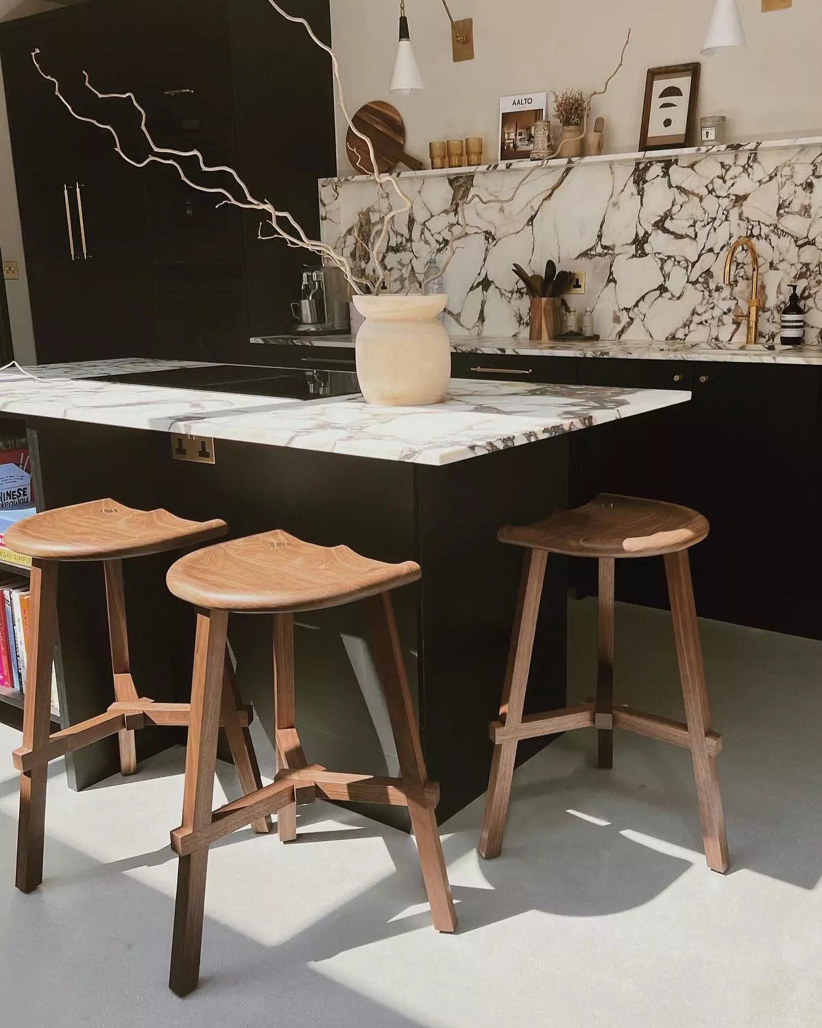 Modern kitchen with marble island and wooden stools
