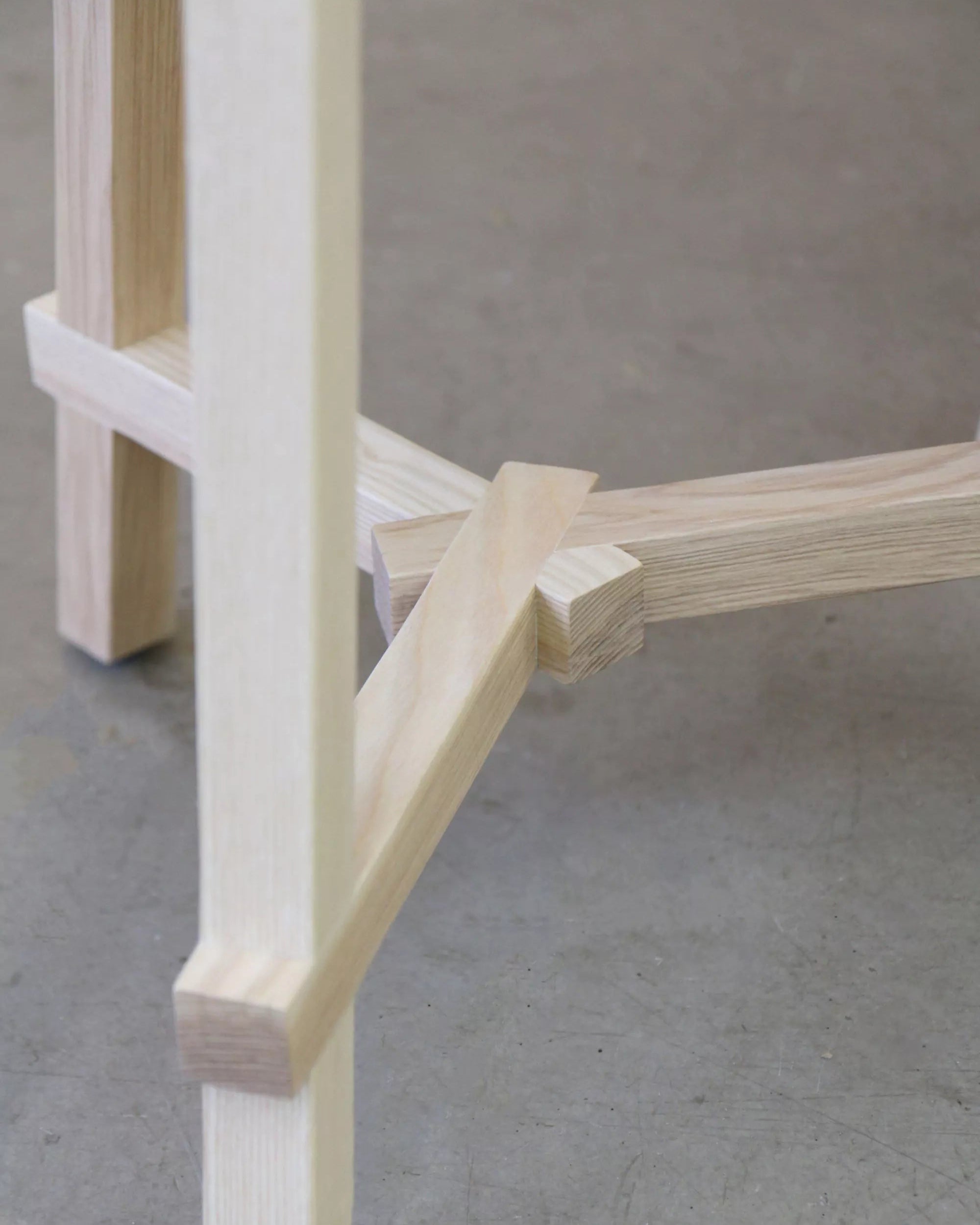 Close-up of a wooden chair leg on a concrete floor