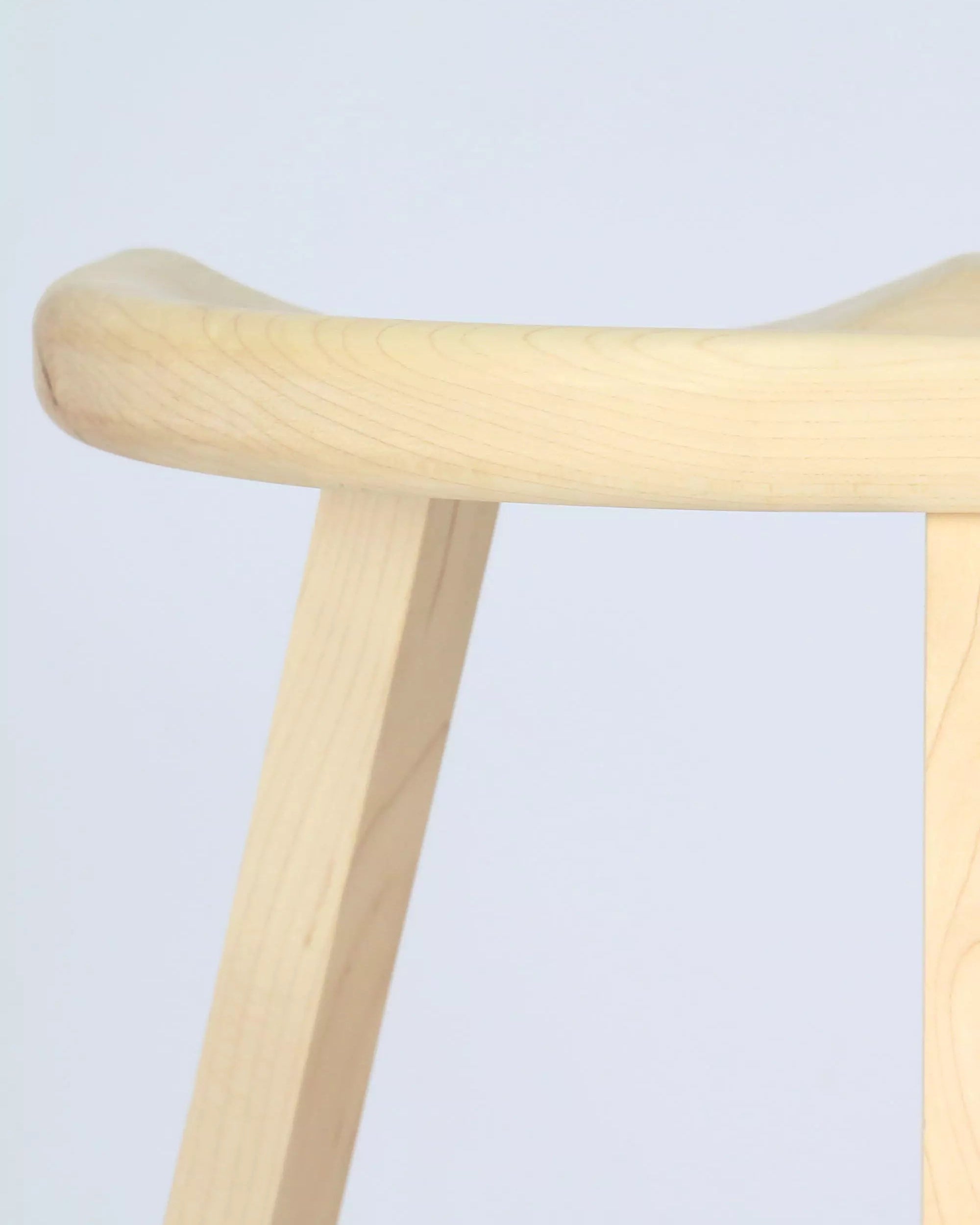 Maple stool close-up with a light finish on a light grey background