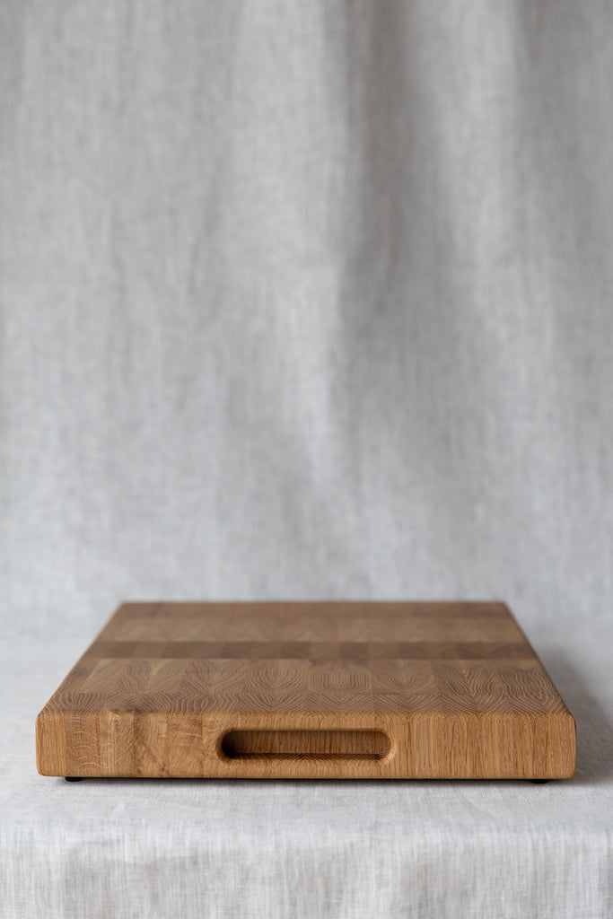 side view of the oak chopping board, showing recessed oval  handles