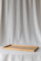 side view of the oak ottoman tray showcasing contrasting walnut corner detail pins