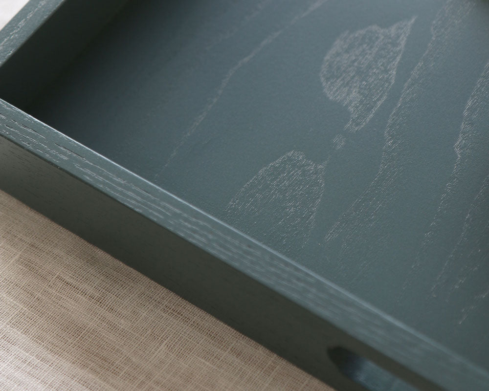 Close-up of the tray’s interior showing visible wood grain beneath the smooth blue-grey painted finish.