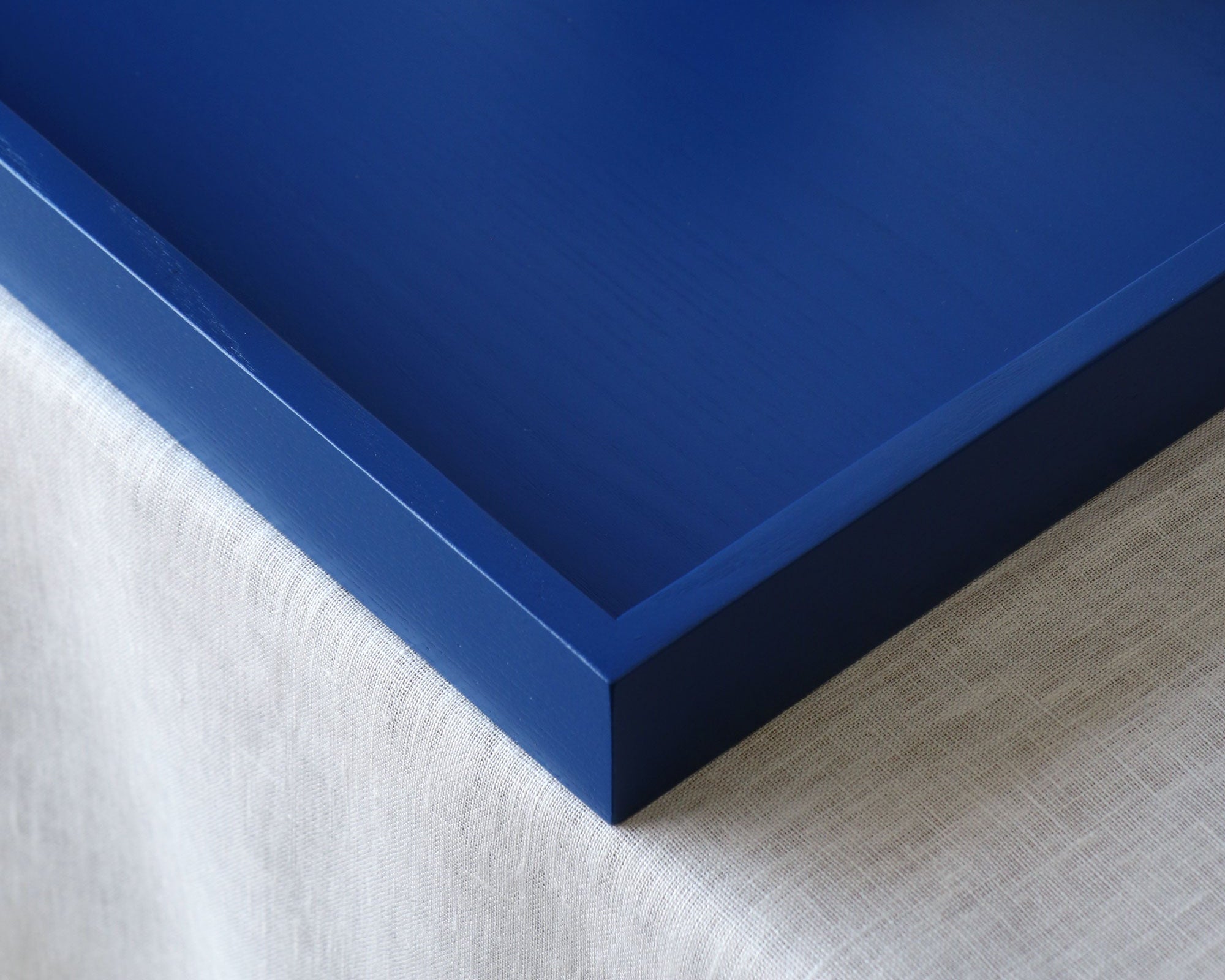 Close-up of a blue tray frame corner on a textured surface