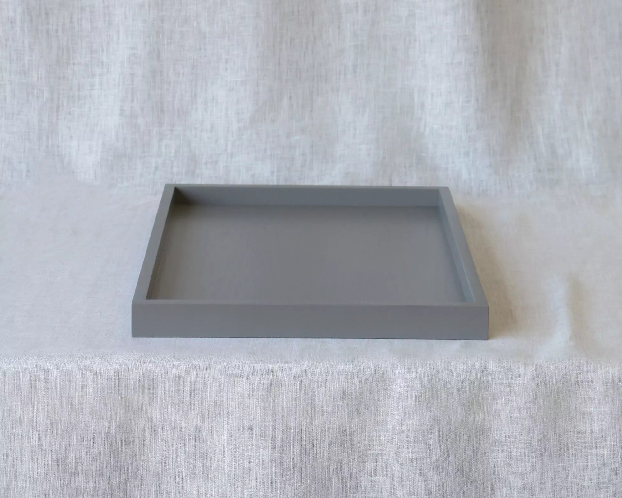 Gray square tray on a textured white surface