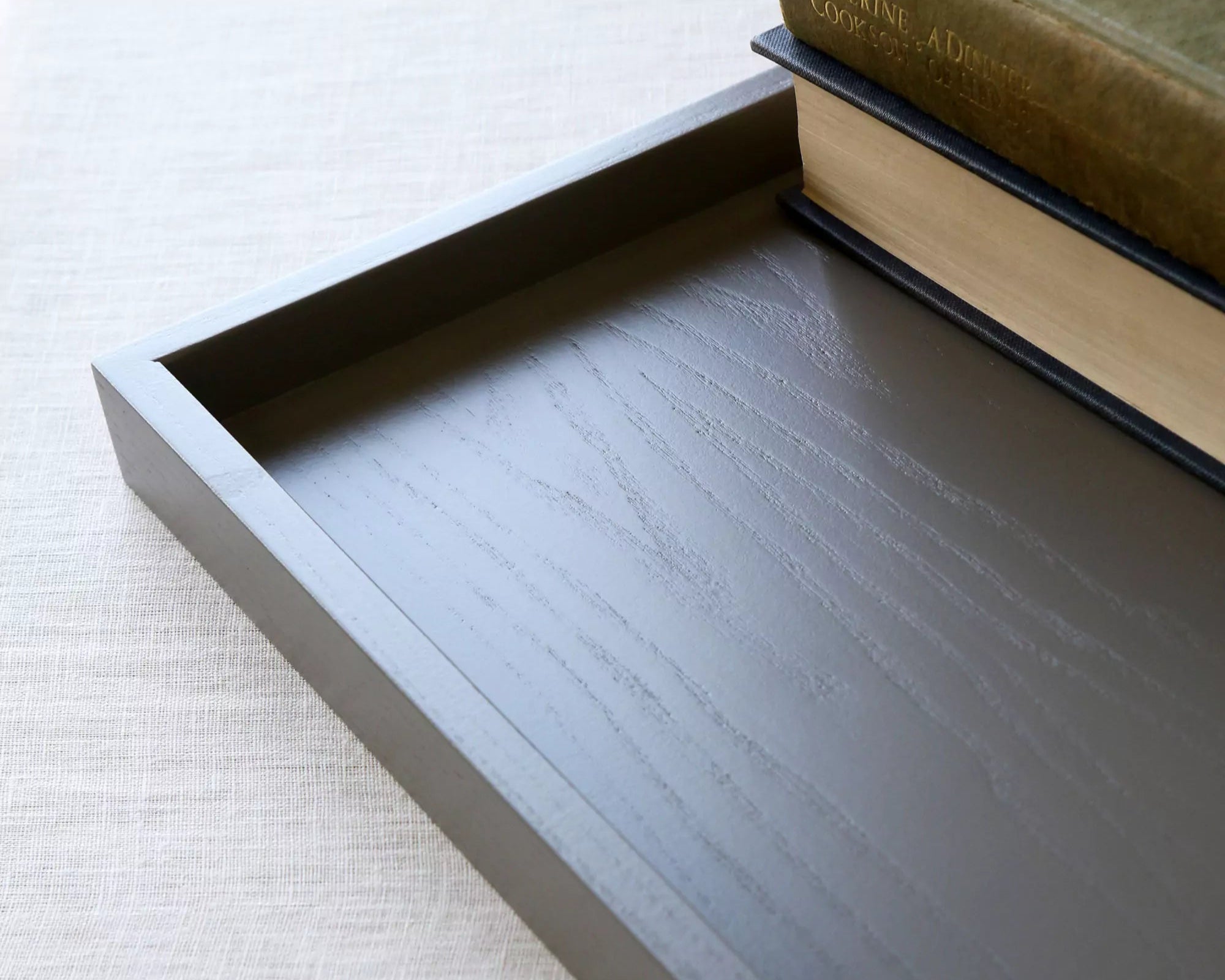 Wooden tray with books on a light background
