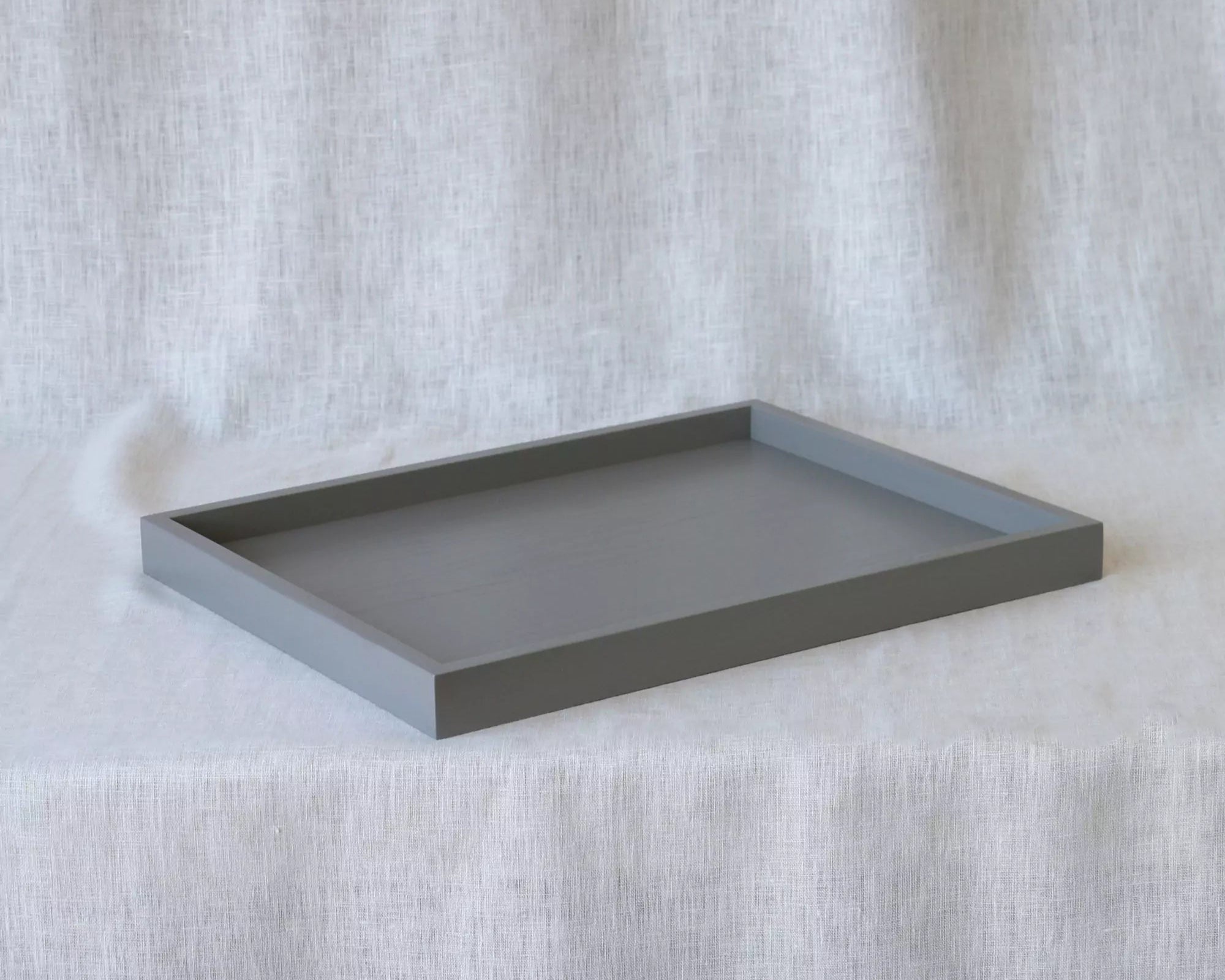 Gray rectangular tray on a textured white surface