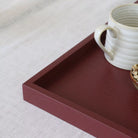 Red tray with a white ceramic cup on a light gray surface