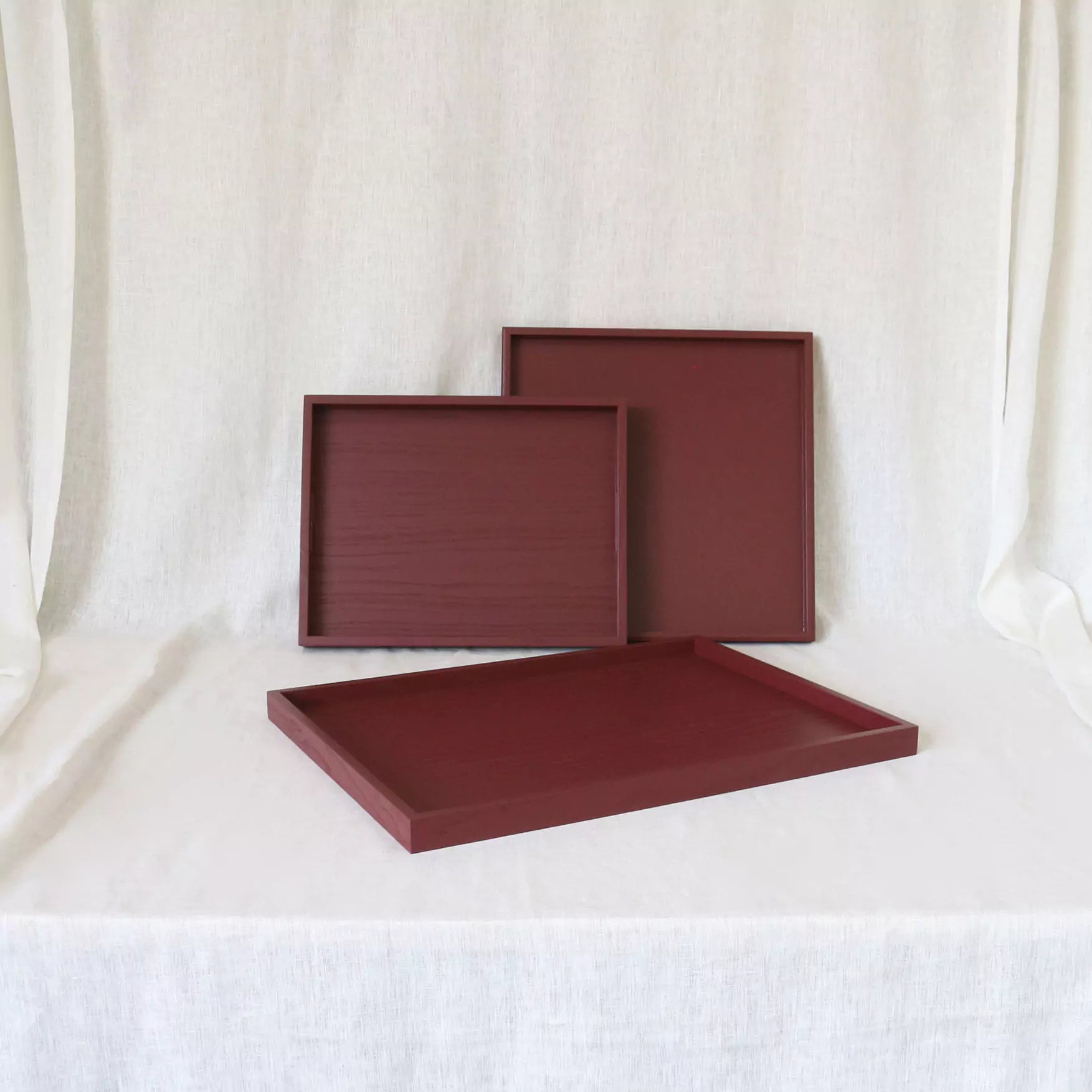 Three maroon trays on a white background