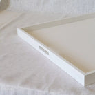 Close-up of the oval-shaped handles of the white square ottoman  tray 