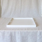 white serving tray with handles on a linen curtain backdrop