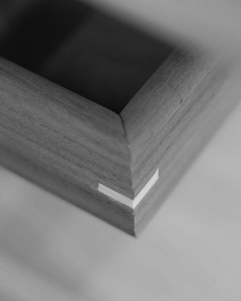 Detailed close-up of a wooden tray corner with a precise dovetail joint, showcasing expert woodworking techniques.