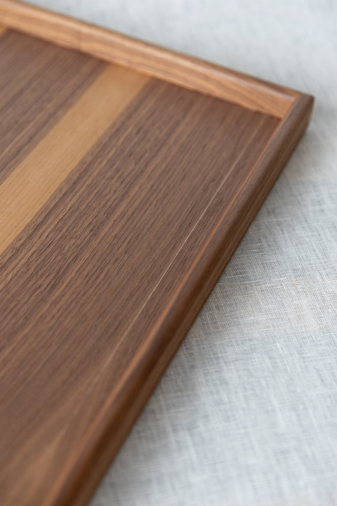 Close-up image of the walnut serving tray 45 x 35cm , and a thin imperfection glue line in the top surface of the tray. this imperfection is hardly noticeable. 