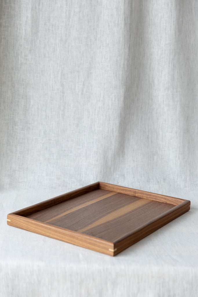 side view of the walnut serving tray 45 x 35cm , showcasing the contrasting corner pin detail