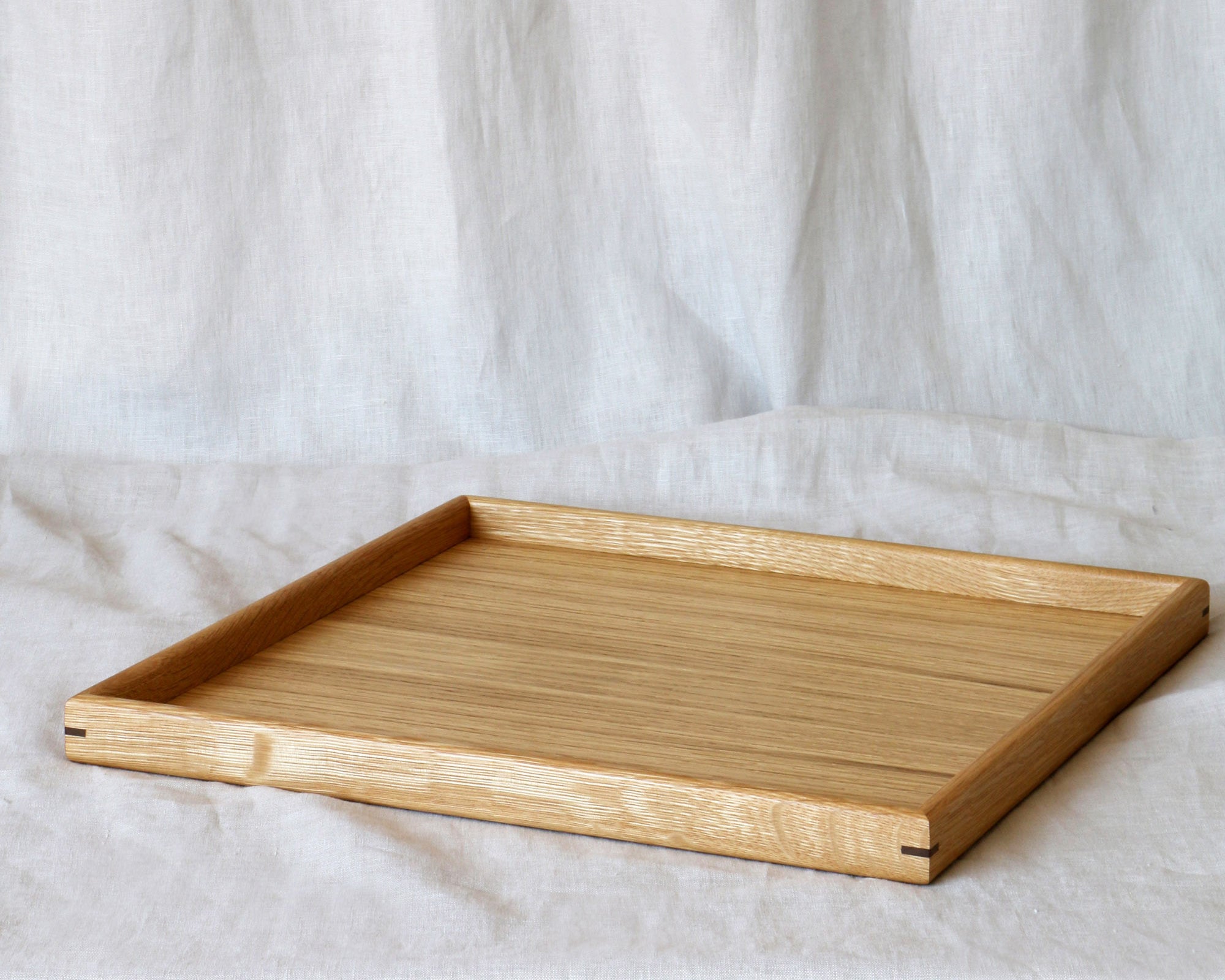 A close-up of a handcrafted tray, highlighting its elegant oak wood grain and precise craftsmanship, ideal as a coffee table tray.