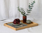 A decorative tray styled with books, a ceramic vase, and fresh greenery, perfect as a wooden tray for footstool or a coffee table tray.