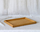 A large coffee table tray, featuring fine joinery details and a natural oak finish, designed for functional elegance.