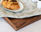 A coffee table tray styled with breakfast essentials, including a croissant, coffee, and fresh fruit.