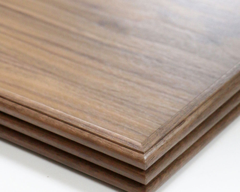 A handcrafted tray in walnut, set on a kitchen counter, styled with a candle, books, and a mortar and pestle, adding a sophisticated touch to the decor.
